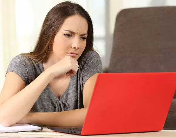 Low quality pictures on a website is one of the top website mistakes - woman looking at low quality pictures on a website on her laptop.